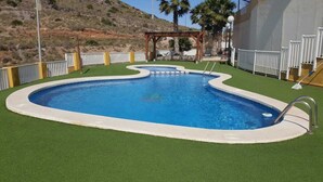 A swimming pool with a wooden pergola, surrounded by white railings and green artificial turf. - Apartment in Cabo de Palos (Cabo de Palos)