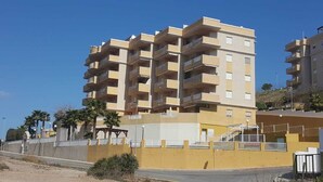 A multi-story residential building with balconies, a gated entrance, and a clear sky. - Apartment in Cabo de Palos (Cabo de Palos)