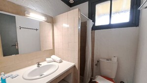 Een badkamer met een wastafel, spiegel, toilet en douchegordijn.