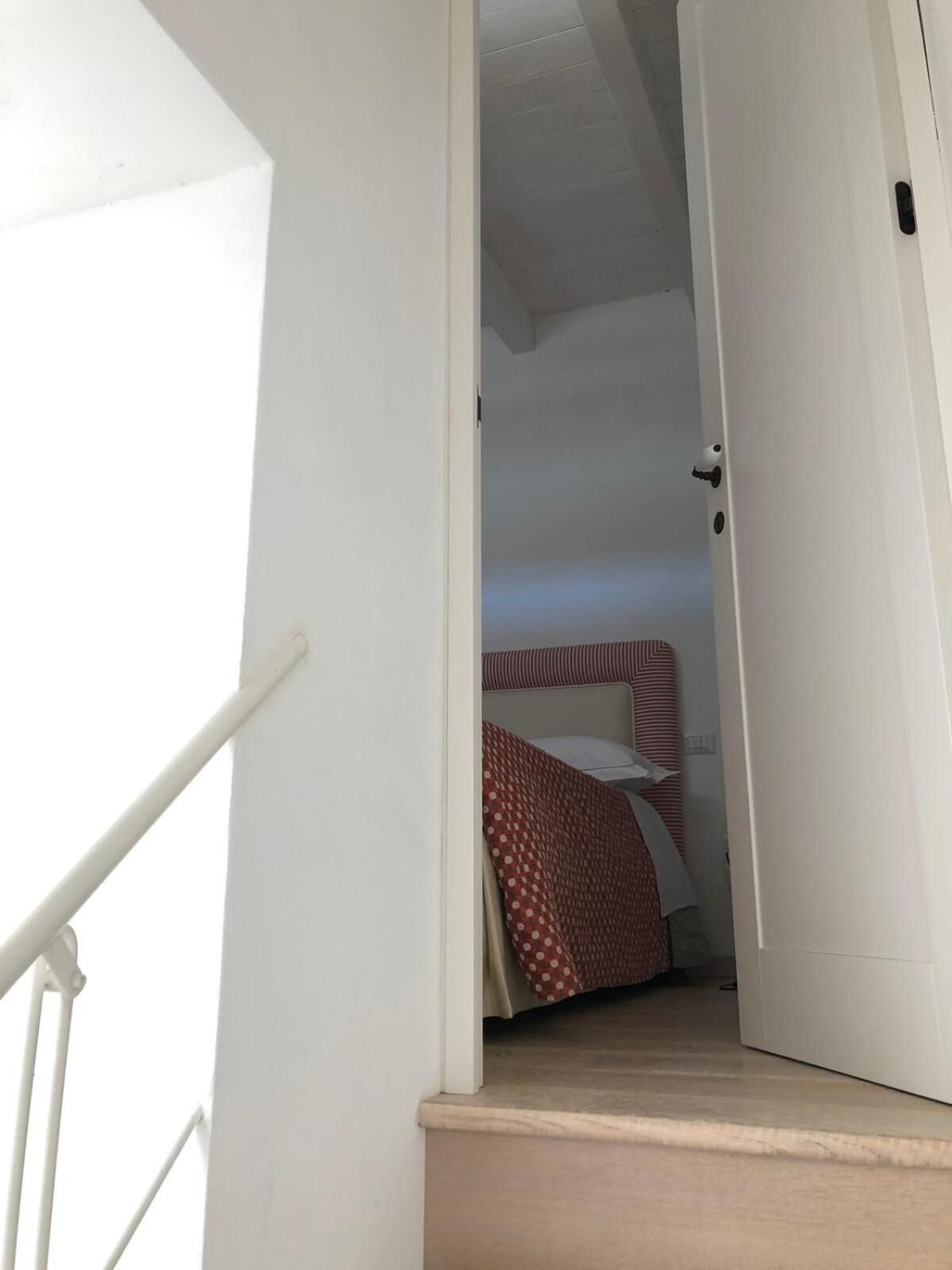 A staircase leading to a room with a bed and a door.