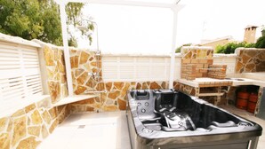 An outdoor hot tub area with stone walls and a pergola. - Finca basket, wheelchair accessible, stone villa by the sea. (Els Poblets)