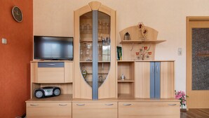 Eine Holzunterhaltungseinheit mit Fernseher, Radio und Schrank mit Glastüren.