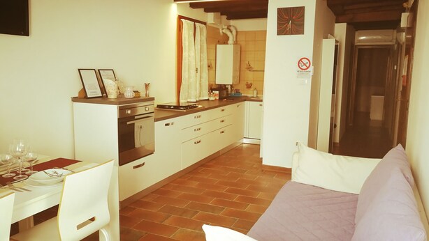 A compact kitchen with a dining area, a sofa, and a refrigerator. - Casa Elia Venice ... (Venezia)