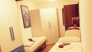 A hotel room with two beds, a wardrobe, a mirror, and a framed picture on the wall. - Casa Elia Venice ... (Venezia)
