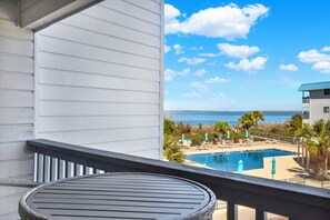 A balcony with a view of a swimming pool and the ocean. - Unit 217b, 1 bedroom 1 bath condo, Bay/Beach front condo (Tybee Island)