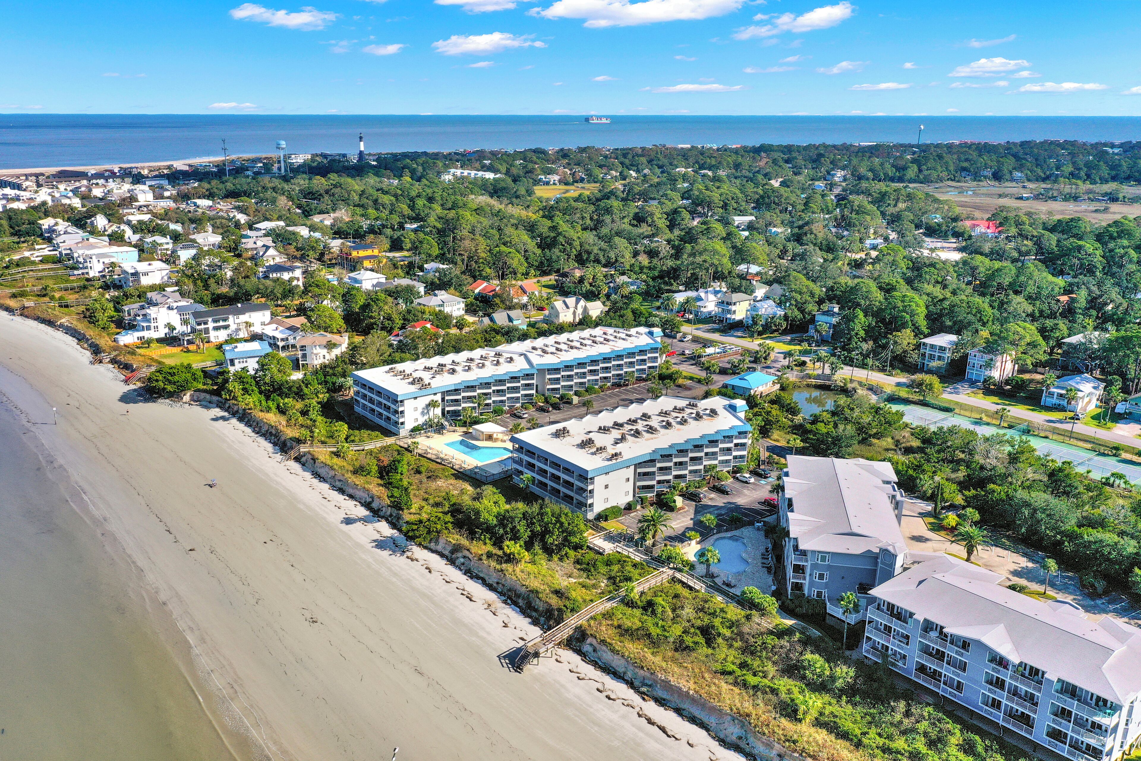 A coastal hotel with multiple buildings, a beach, and a view of the sea.
