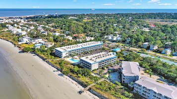 A coastal hotel with multiple buildings, a beach, and a view of the sea.