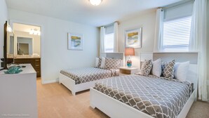 A bedroom with two beds, a desk, a mirror, and artwork on the walls. - Windsor at Westside Exec Villas- 1639la (Kissimmee)