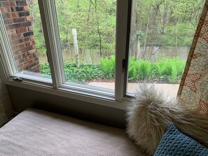 A room with a large window, a brick wall, and a view of greenery outside. - River's Edge on 30 Acres with Kayaks/Pool/Farm/River/Trails/Pets, near Beach (Union Pier)