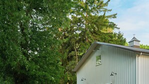 A rustic barn-style building with a fire pit and outdoor seating. - River's Edge on 30 Acres with Kayaks/Pool/Farm/River/Trails/Pets, near Beach (Union Pier)