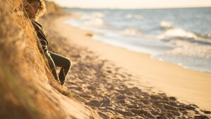 A person sitting on a sandy beach with waves in the background. - River's Edge on 30 Acres with Kayaks/Pool/Farm/River/Trails/Pets, near Beach (Union Pier)