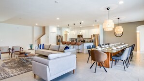 Ein geräumiger Wohnbereich mit Sofa, Couchtisch und Essbereich, der für eine Mahlzeit gedeckt ist.