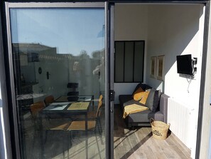 A modern living room with a glass door leading to a patio area. - VACATION HOME, EVERYTHING BY BIKE! (NOIRMOUTIER)