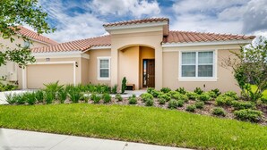 A single-story house with a beige exterior, a red-tiled roof, and a front entrance with a door and window. - Solterra Exec Villas- 6136bod (Davenport)