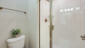 A bathroom with a glass-enclosed shower, a toilet, and a small potted plant. - Storey Lake Exec Villas- 3175pp (Kissimmee)