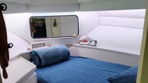 A compact, well-lit cabin with a single bed, a small vanity with drawers, a mirror, and a window with a view. - UNIQUE AND BEAUTIFUL "BONNE-VIE at SEA"<br> (Key Largo)