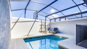 A rooftop swimming pool with a glass enclosure, a lounge area with seating, and a view of the surrounding buildings. - Storey Lake Exec Villas- 4832rc (Kissimmee)