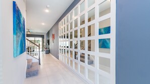 A modern hallway with a staircase, white walls, and a blue accent wall. - Solara Resort Exec Villas- 1542cpc (Kissimmee)