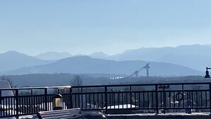 Vista de un paisaje montañoso con un puente a lo lejos.