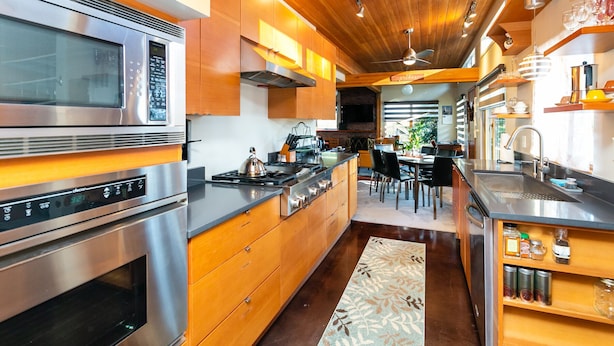 A modern kitchen with stainless steel appliances, wooden cabinetry, and a central island. - Hilltop Hideaway, cozy forest retreat, Portland (Portland)