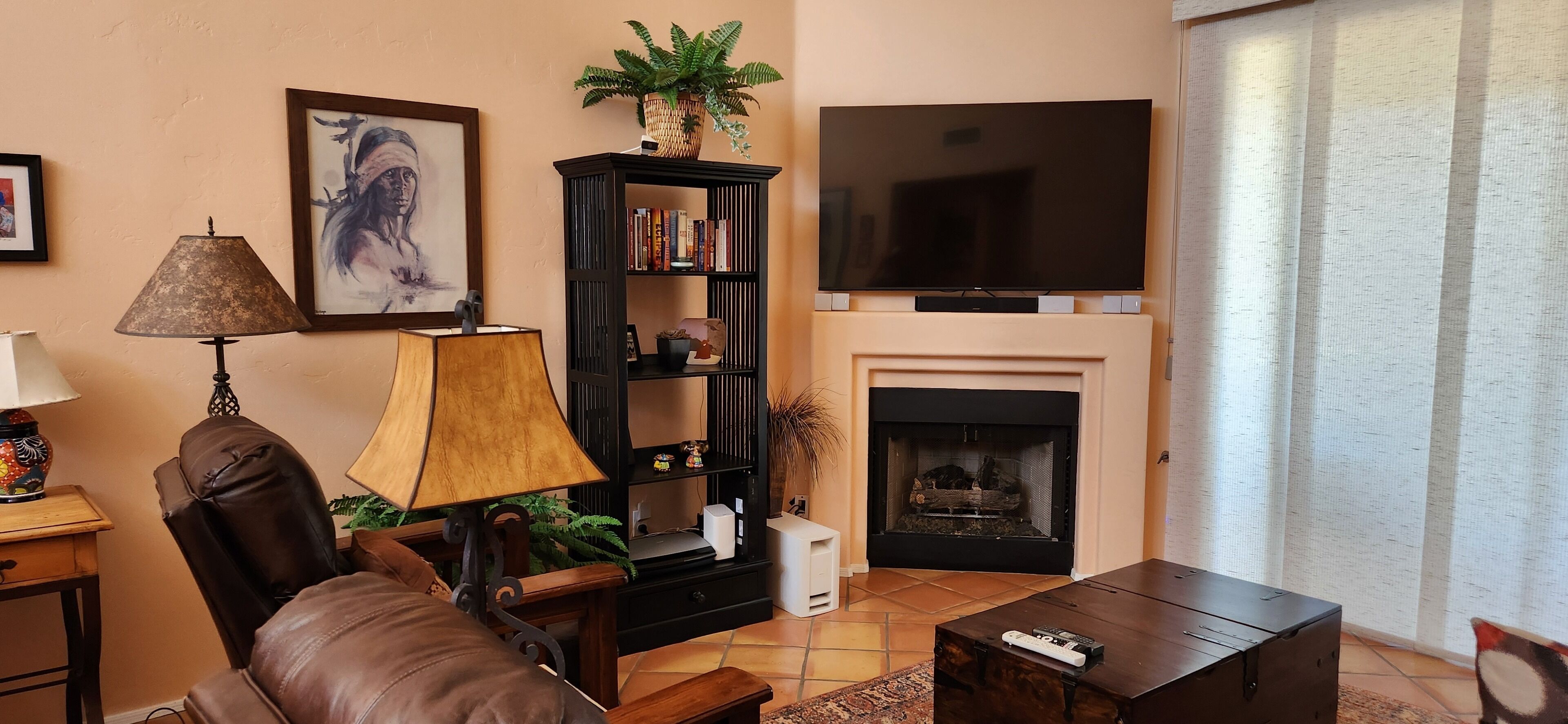 A living room with a fireplace, a television, a bookshelf, and a comfortable seating area.