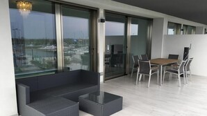 A modern living room with a sofa, coffee table, and dining area with chairs.
