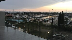 A marina with boats docked, a swimming pool, and a view of the sunset.