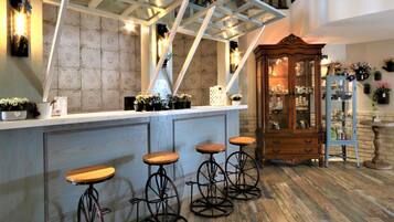 A bar area with a wooden cabinet, a white counter, and four bar stools.
