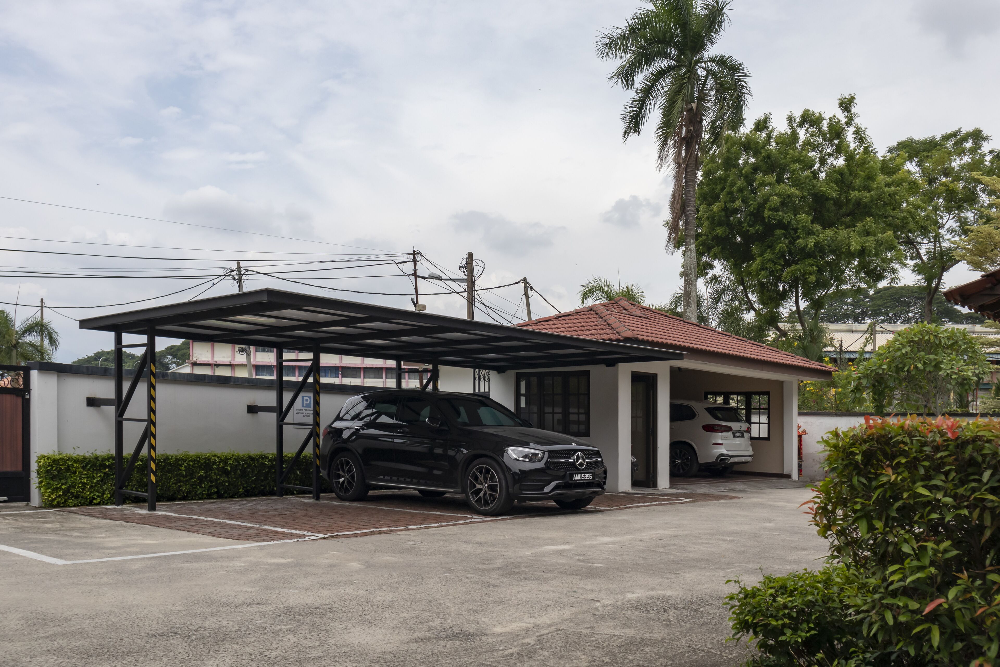 Un área de estacionamiento techada con un coche negro estacionado bajo un refugio.