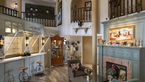 Ein großzügiger Wohnbereich mit Kamin, Treppe und hoher Decke.