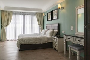 Een slaapkamer met een bed, nachtkastjes, een kaptafel en een spiegel.