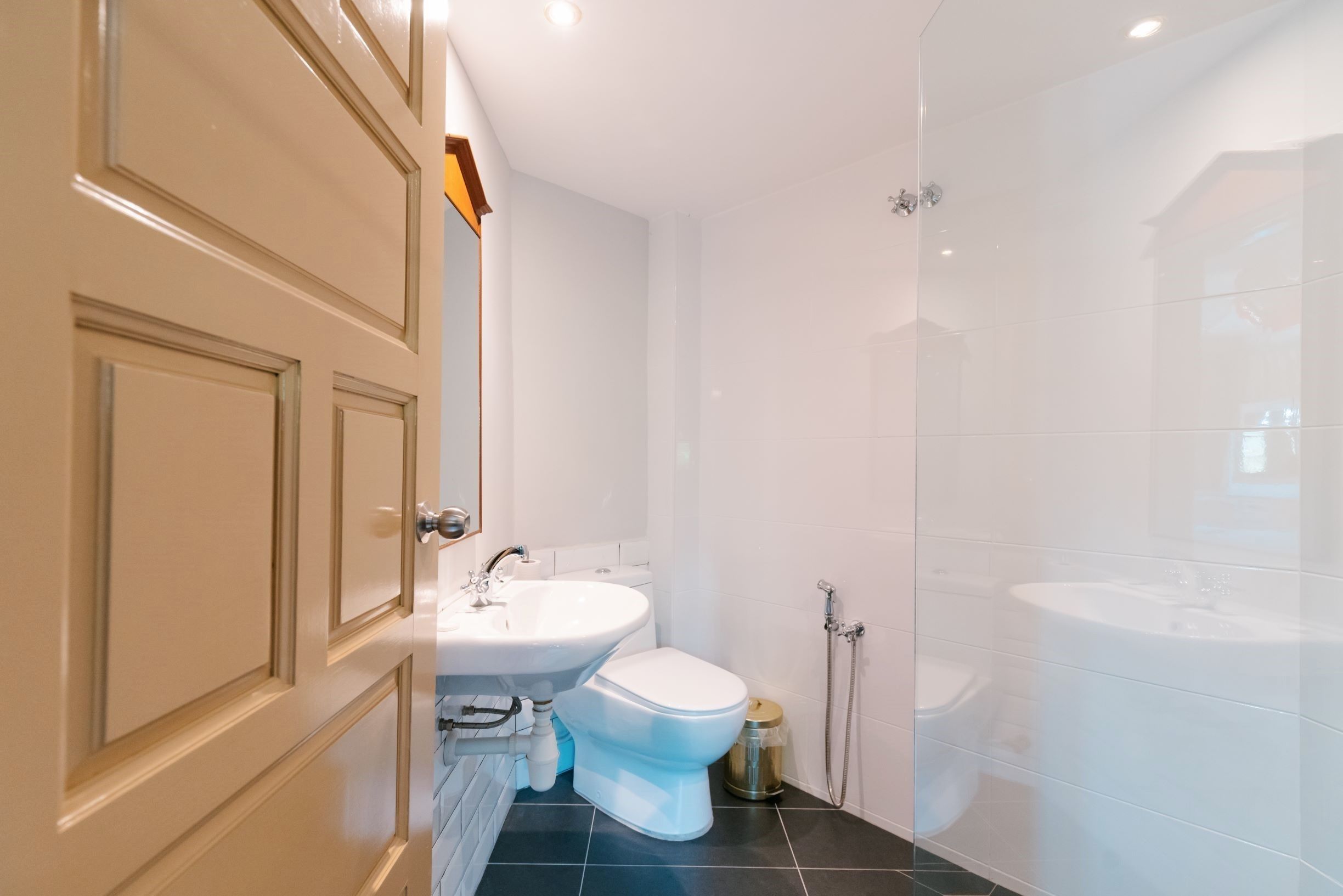 A modern bathroom with a toilet, sink, and shower.