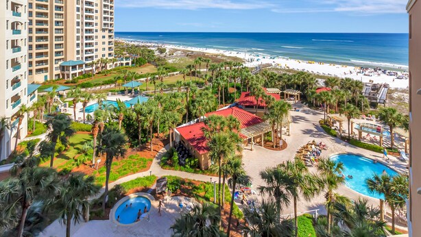 A resort with multiple swimming pools, a beach, and a view of the ocean.