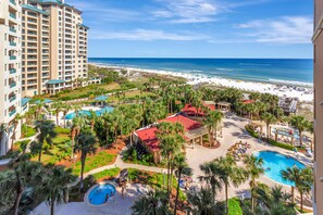 Ein Resort mit mehreren Schwimmbecken, einem Strand und Blick auf den Ozean.