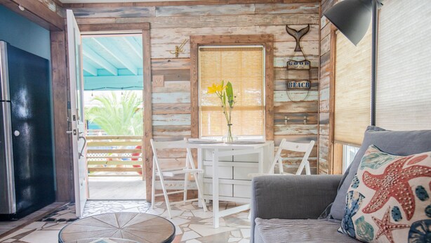 Une pièce confortable avec un canapé, une petite table et une fenêtre donnant sur l’extérieur.