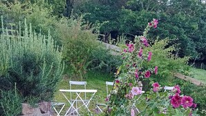 A garden with a stone staircase leading up to a white bench.