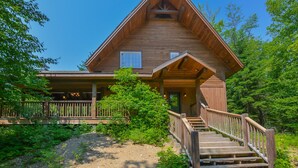 A wooden cabin with a porch and a staircase leading to the entrance. - Chalet Le Supérieur/Tremblant- Lac-Supérieur/Spa++ (Lac-Supérieur)