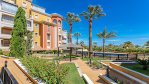 Un cortile con un gazebo, palme e una piscina.