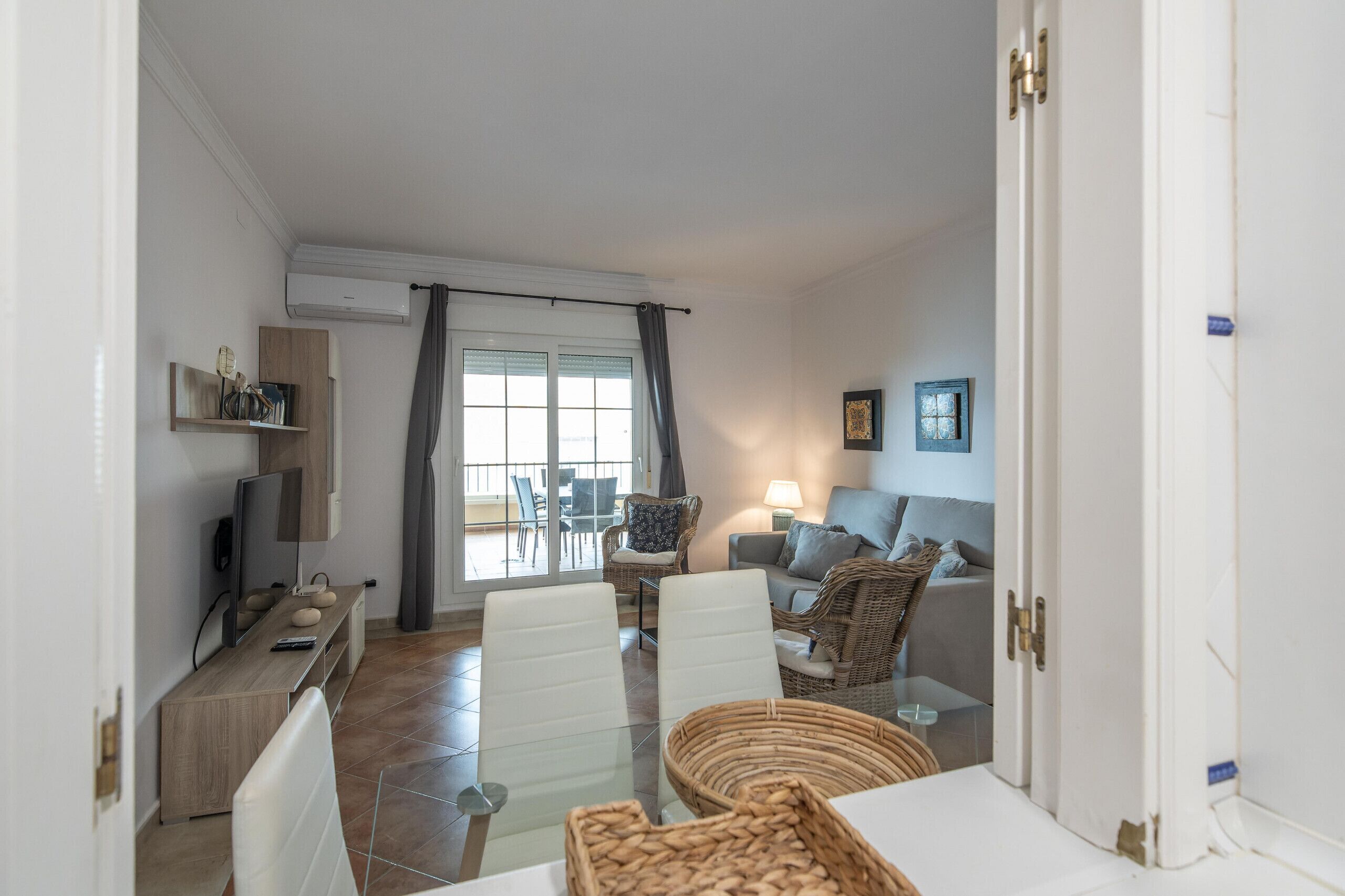 Ein modernes Wohnzimmer mit einer Couch, einem Esstisch mit Stühlen und einem Fernseher.