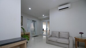 Uma sala de estar moderna com um sofá, uma mesinha redonda e uma escrivaninha.