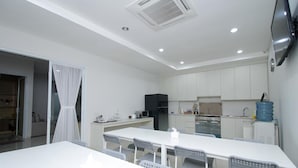 Cozinha moderna com armários brancos, micro-ondas e dispensador de água.