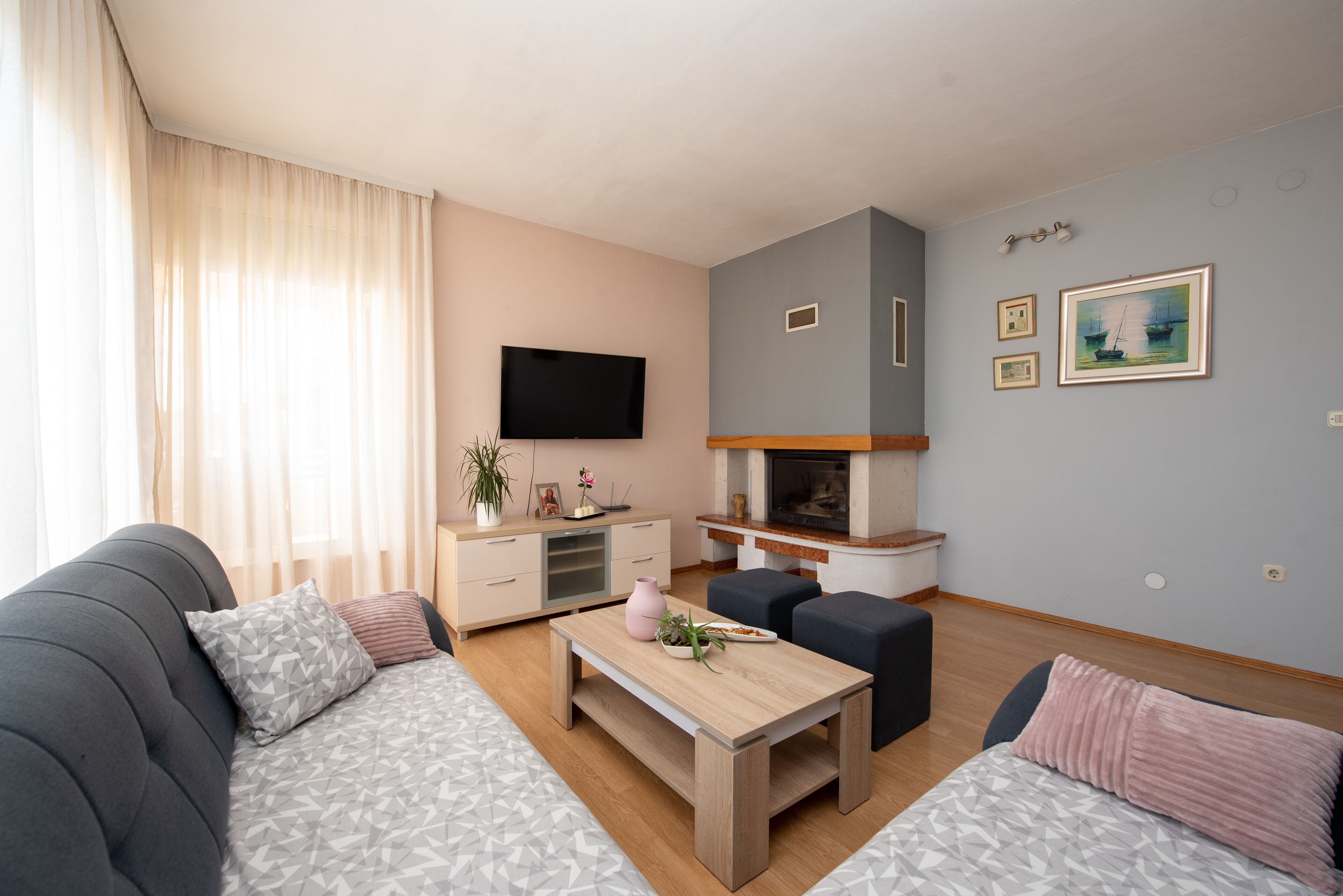 Ein modernes Wohnzimmer mit Sofa, Couchtisch und Fernseher.