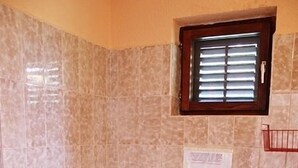 Un bagno con il water, un lavandino e una finestra.