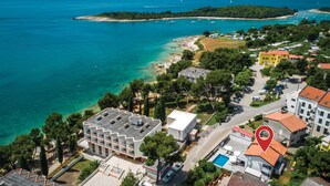 An aerial view of a coastal area with a hotel, clear turquoise waters, and a small island in the distance. - Stunning home in Banjole (Banjole)