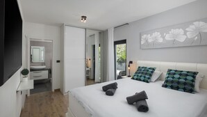 A modern bedroom with a large bed, a bedside table, a mirror, and a view of the outside. - Stunning home in Banjole (Banjole)
