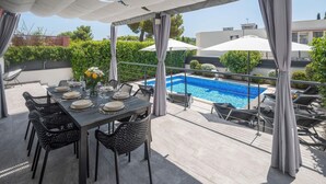 A covered outdoor dining area with a pool in the background. - Stunning home in Banjole (Banjole)