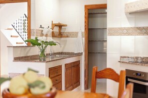 A kitchen with wooden cabinets, a granite countertop, a sink, and an oven.