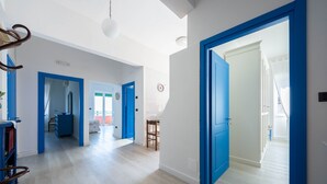 A spacious hallway with light wooden flooring and blue doors leading to different rooms. - Casa Roberta (Maiori)