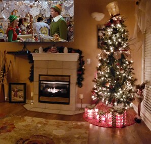 Una sala de estar con chimenea, un árbol de Navidad y decoraciones festivas.