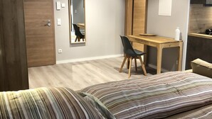 Un dormitorio moderno con una cama grande, un escritorio y un espejo.